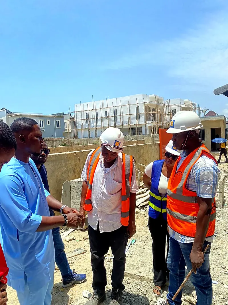 Colleagues in hard hats and safety vests at a building site